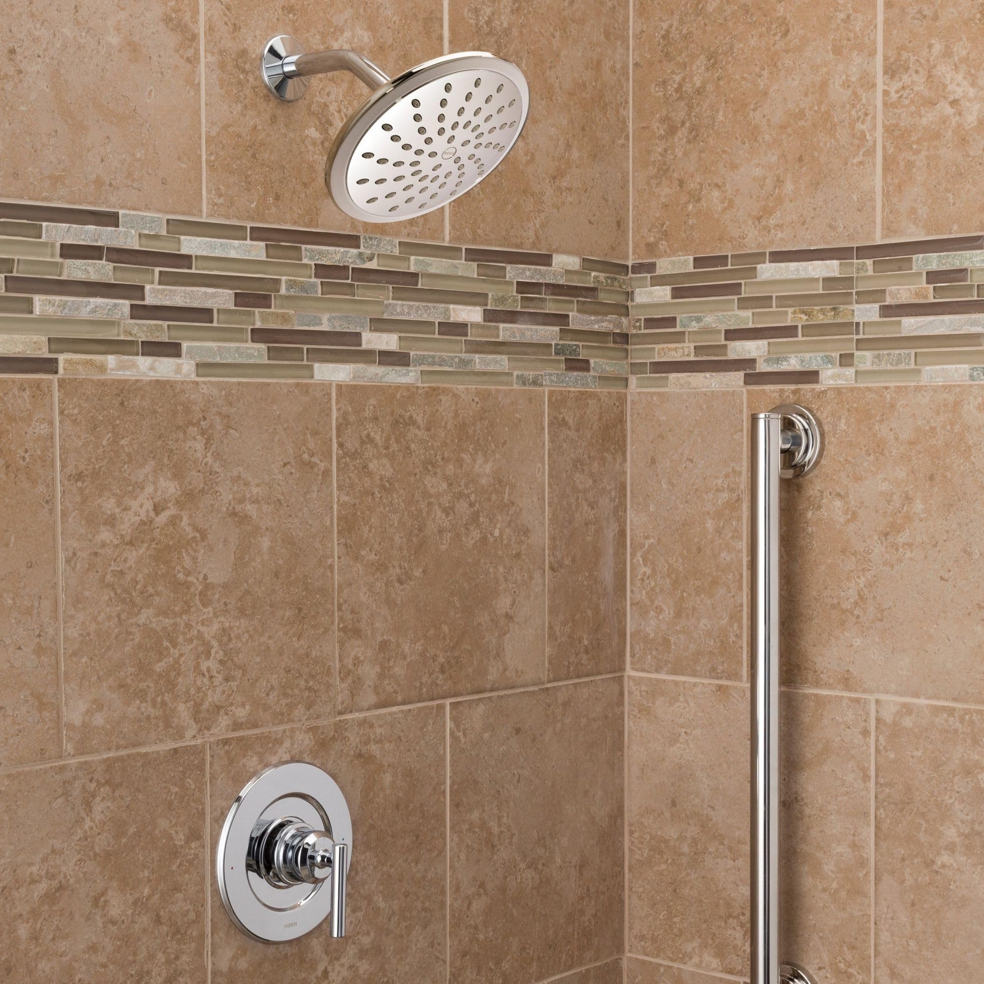Chrome single-handle shower trim with round showerhead and control valve mounted on beige tile wall.
