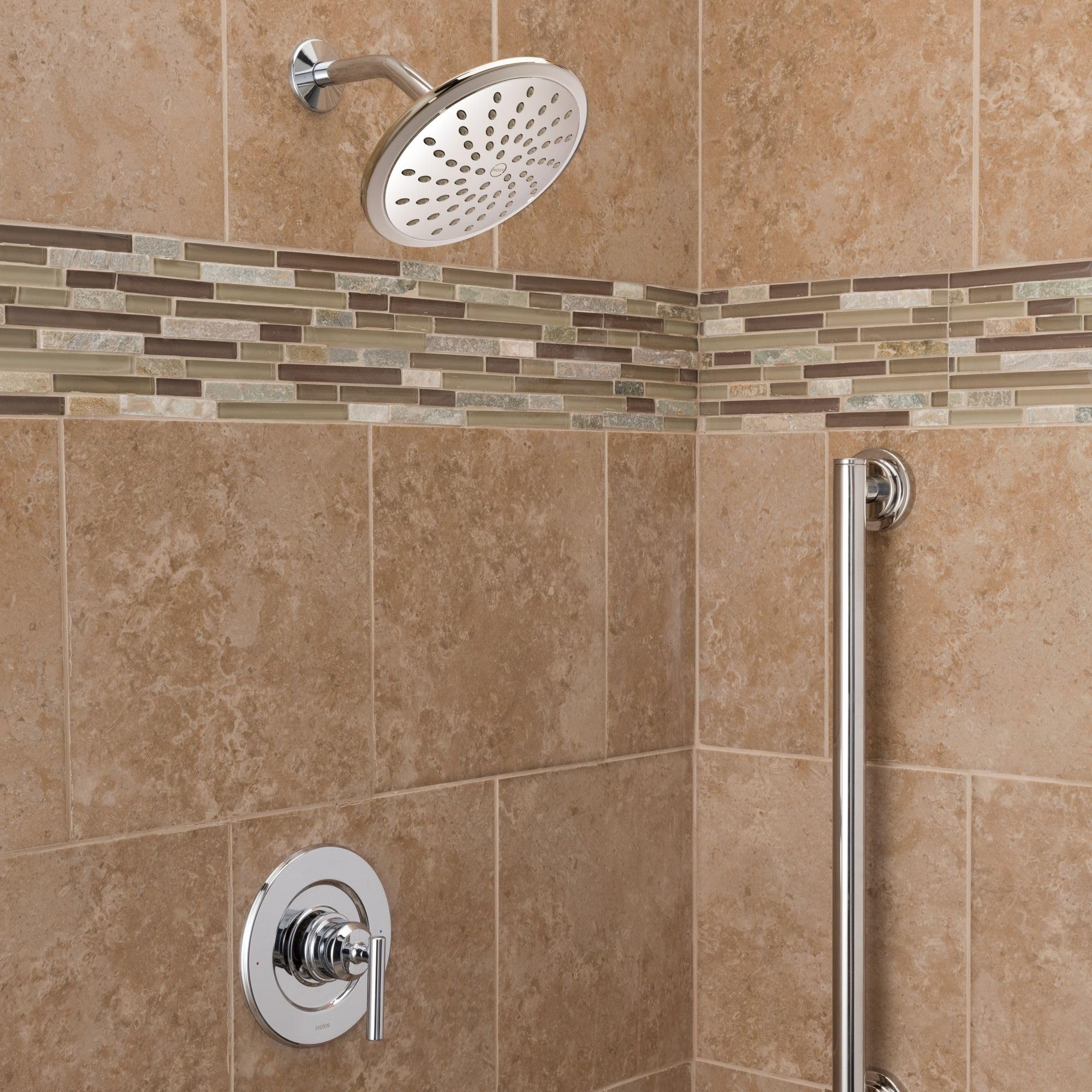 Chrome single-handle shower trim with round showerhead and control valve mounted on beige tile wall.