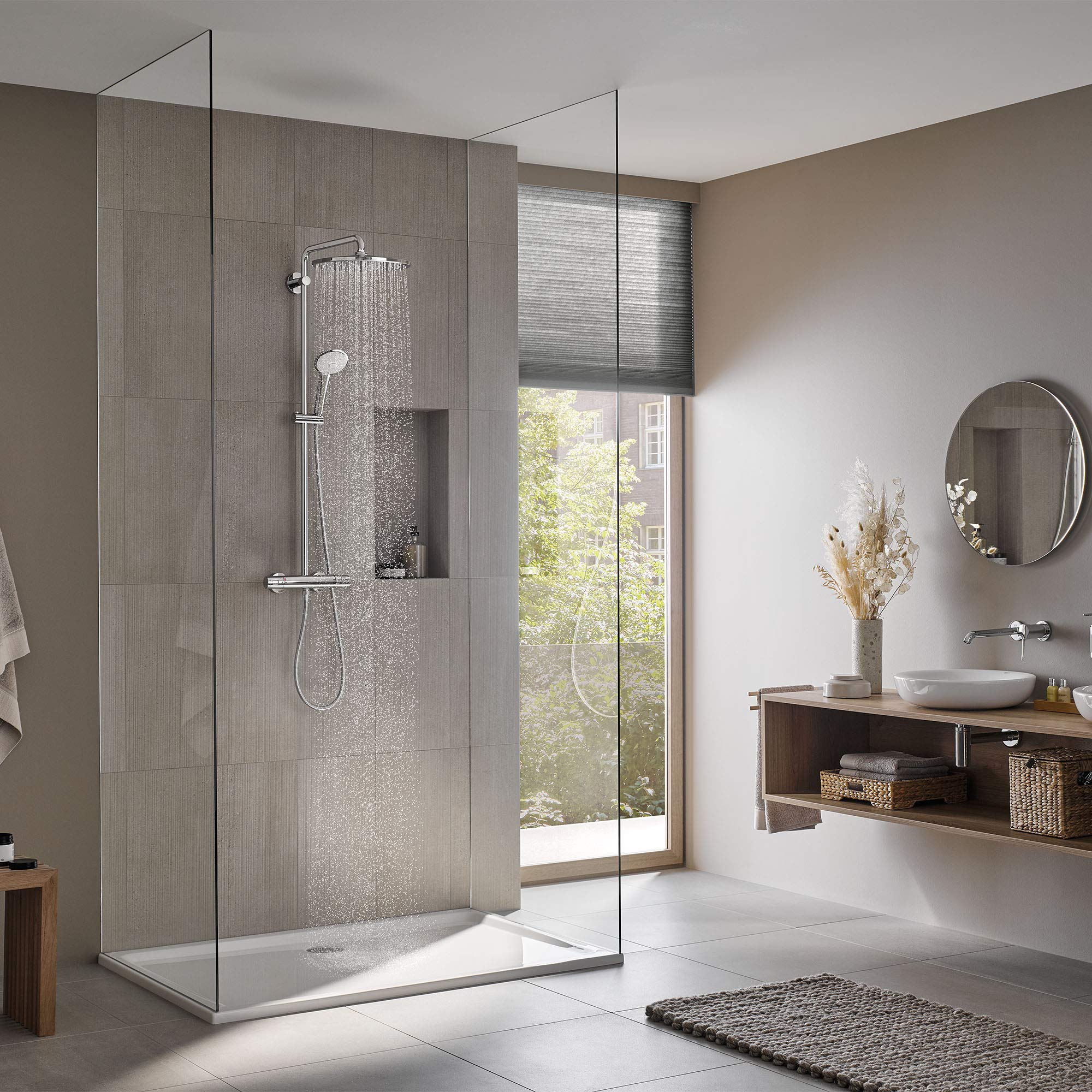 Chrome thermostatic shower system with overhead rainfall showerhead and handheld spray mounted on tiled shower enclosure wall