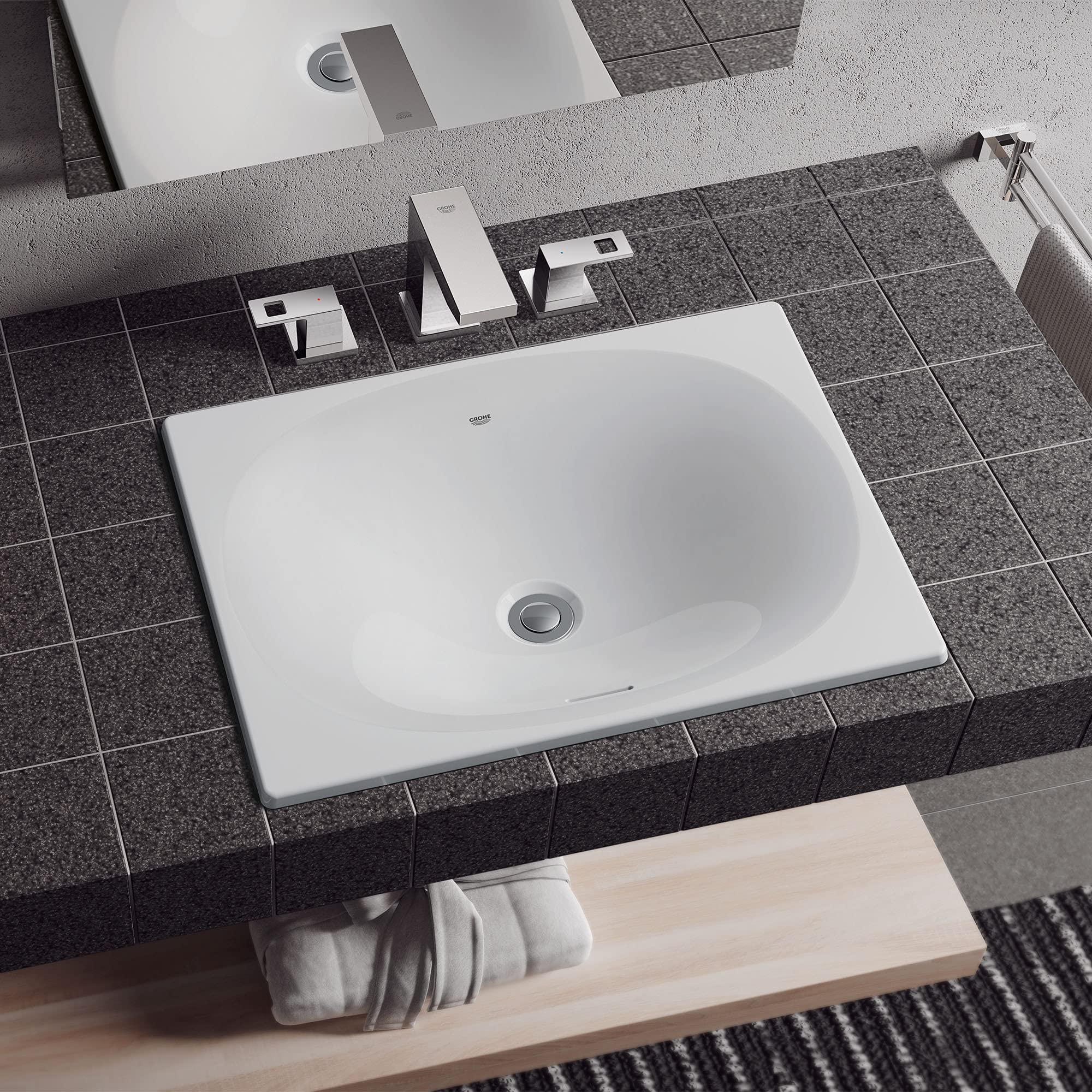 White square under-counter bathroom sink installed in dark gray tile countertop with chrome faucet and fixtures.