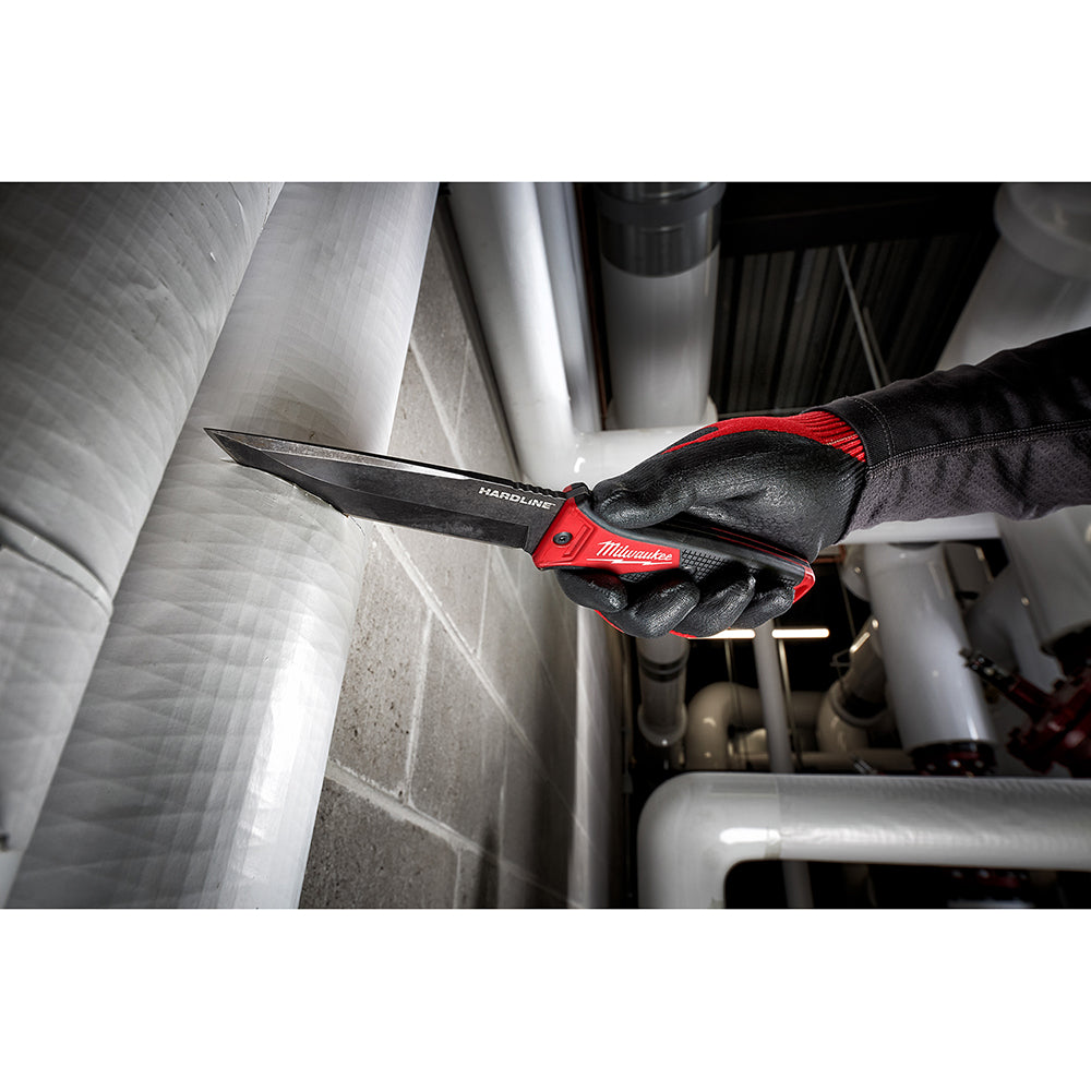 Milwaukee 5-inch fixed blade knife with black blade and red handle being held over metal ducting.