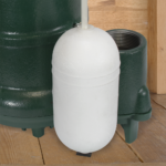 White cylindrical submersible sump pump with dark green pump units visible in background.