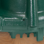 Green cast iron submersible sump pump with ridged base and outlet port.