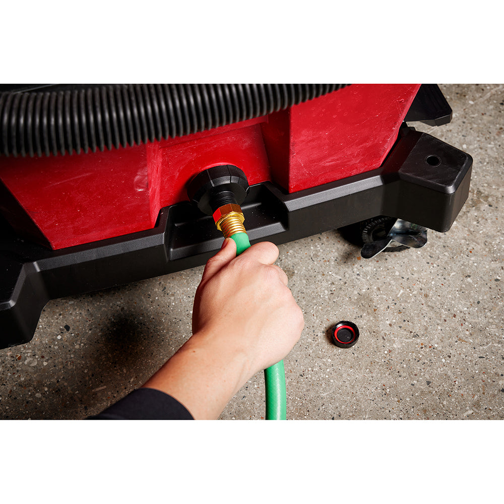 Black and brass drain adapter with green hose connected to red and black Milwaukee equipment base.