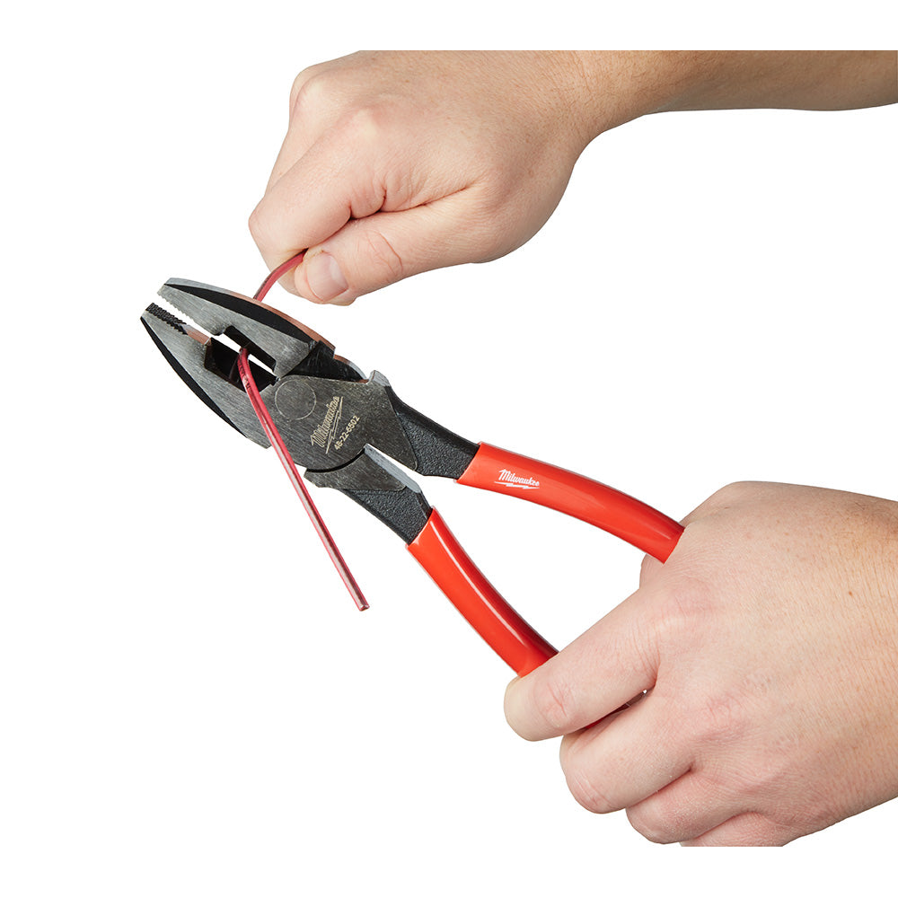 Milwaukee diagonal cutters with red handles cutting red wire, held in both hands.
