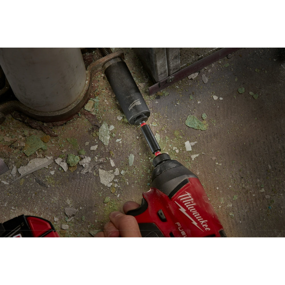 Black cylindrical magnetic bit tip holder attached to red Milwaukee drill with extended shaft visible.
