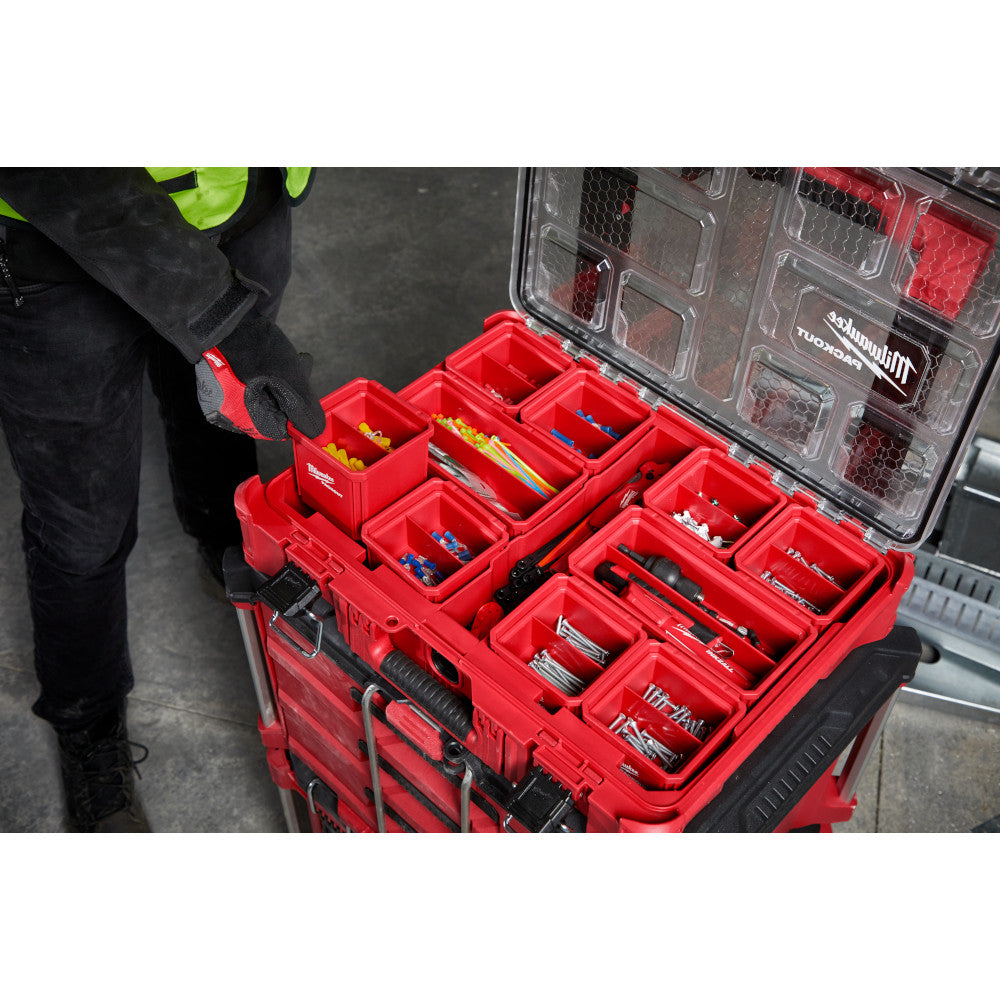 Two red Milwaukee PACKOUT storage bins with removable compartments, one open showing organized fasteners and small parts.