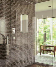 Rectangular lighted mirror mounted on dark tile shower wall next to glass enclosure.
