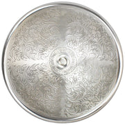 White bronze round bathroom sink with ornate scrollwork pattern and center drain opening, viewed from above.