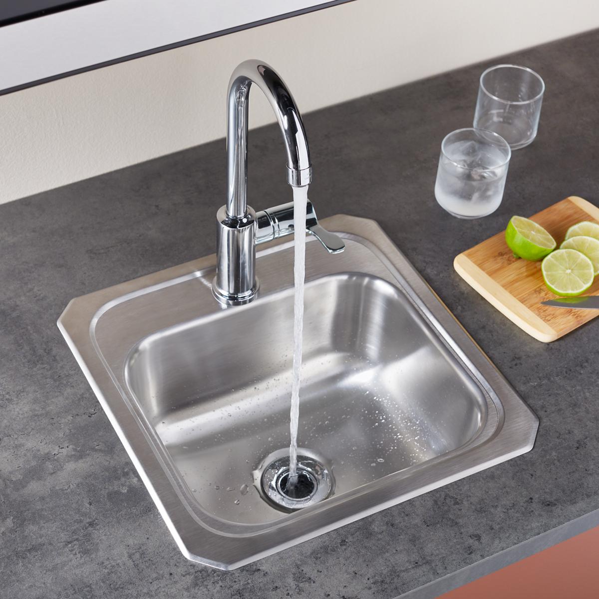 Nickel-plated brass drain fitting with stainless steel strainer basket installed in kitchen sink basin.