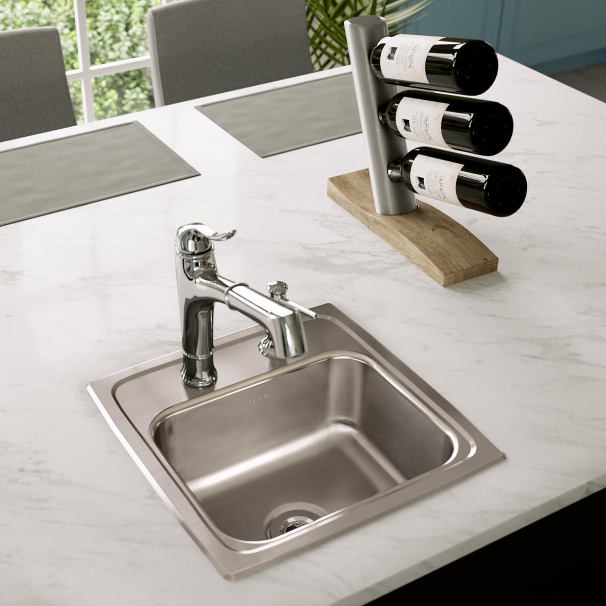 Stainless steel square drop-in bar sink with single bowl and one faucet hole mounted in marble countertop.