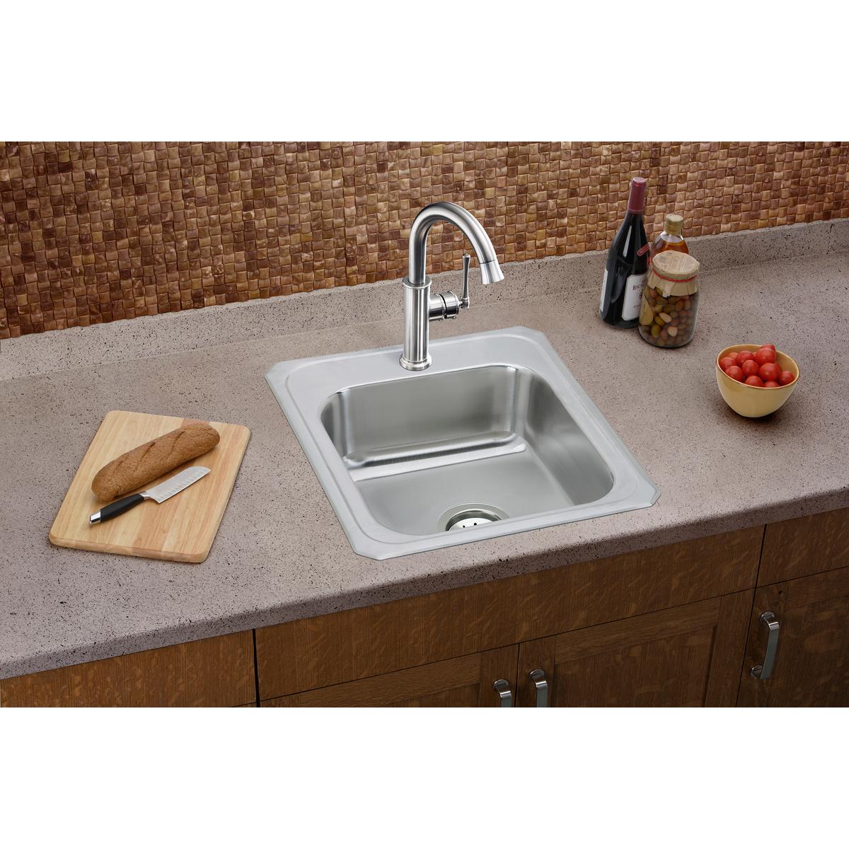 Stainless steel drop-in sink with single bowl, white rim, and two faucet holes installed in countertop.