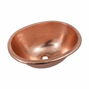 Polished copper oval sink with hammered texture and single drain opening.