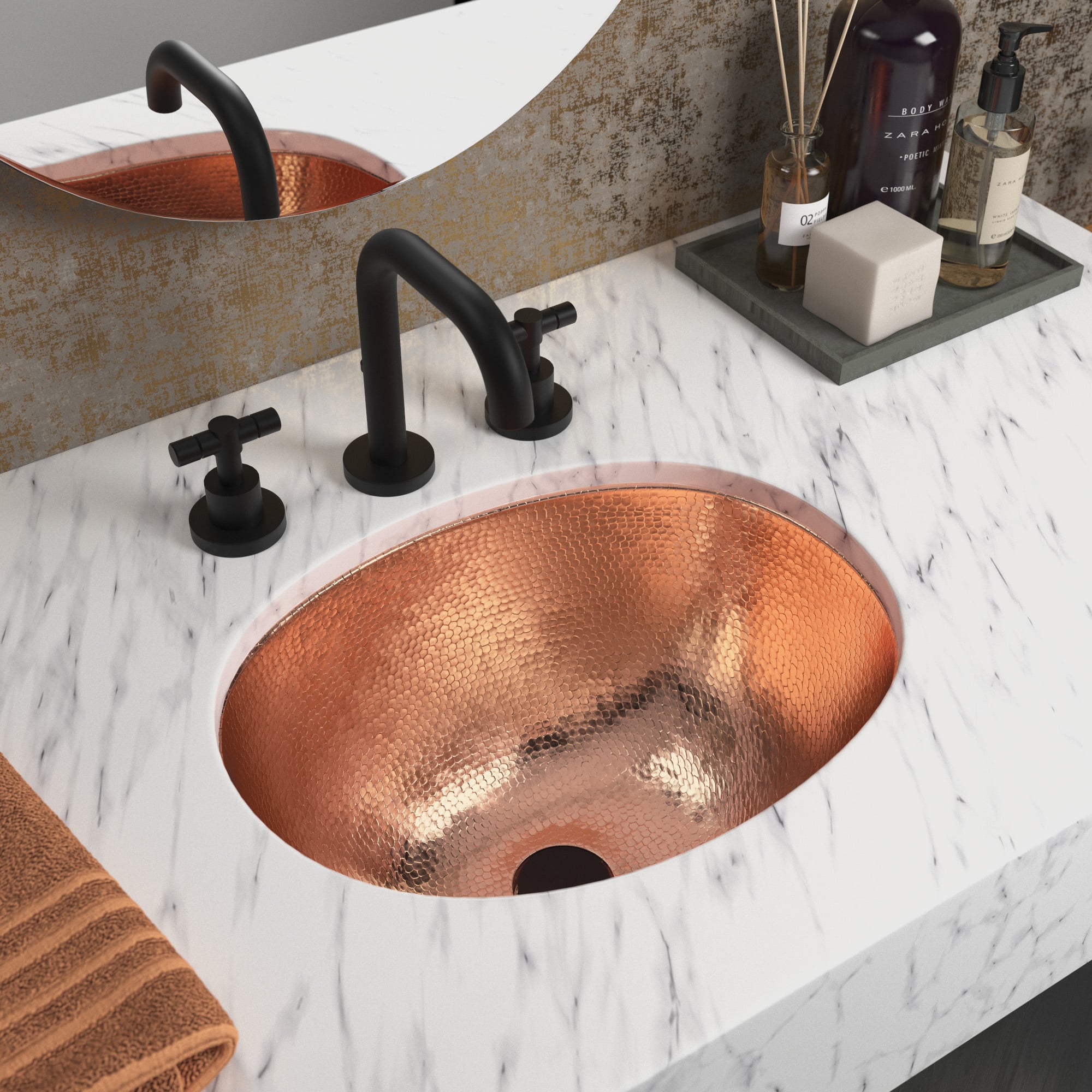 Polished copper oval sink with hammered texture installed in white marble countertop with black faucet.