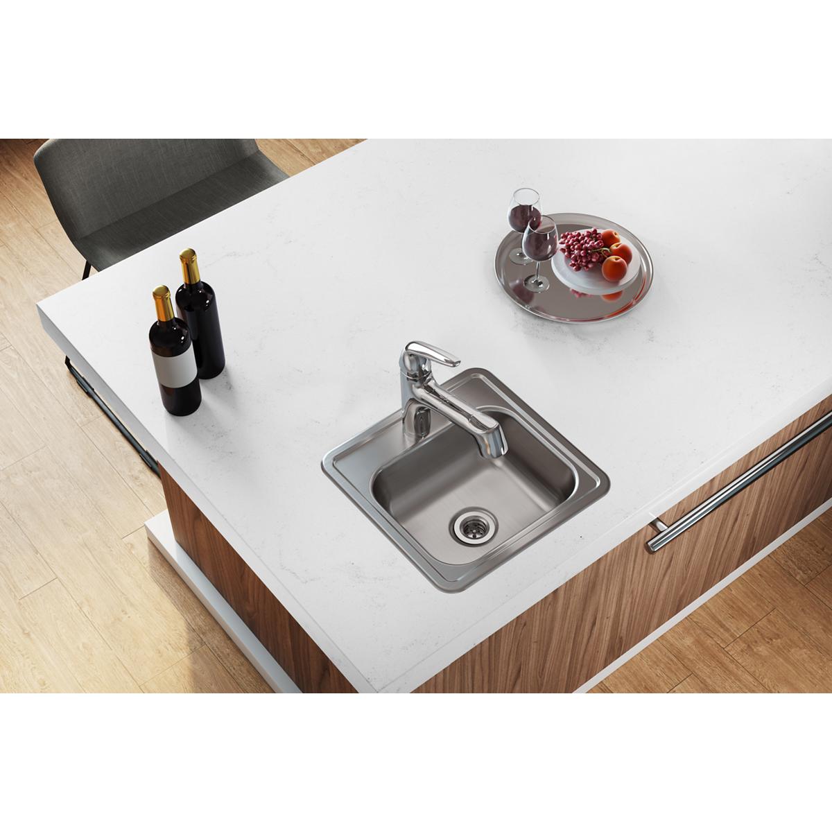Stainless steel drop-in bar sink with single bowl and 2" drain opening installed in white countertop with faucet.