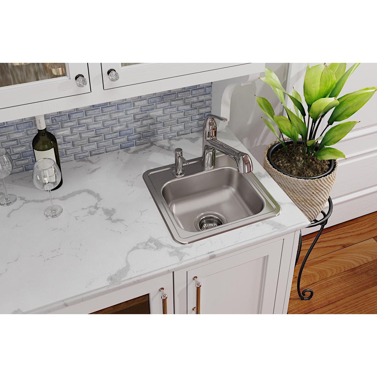 Stainless steel drop-in bar sink with single bowl and two faucet holes installed in white countertop.