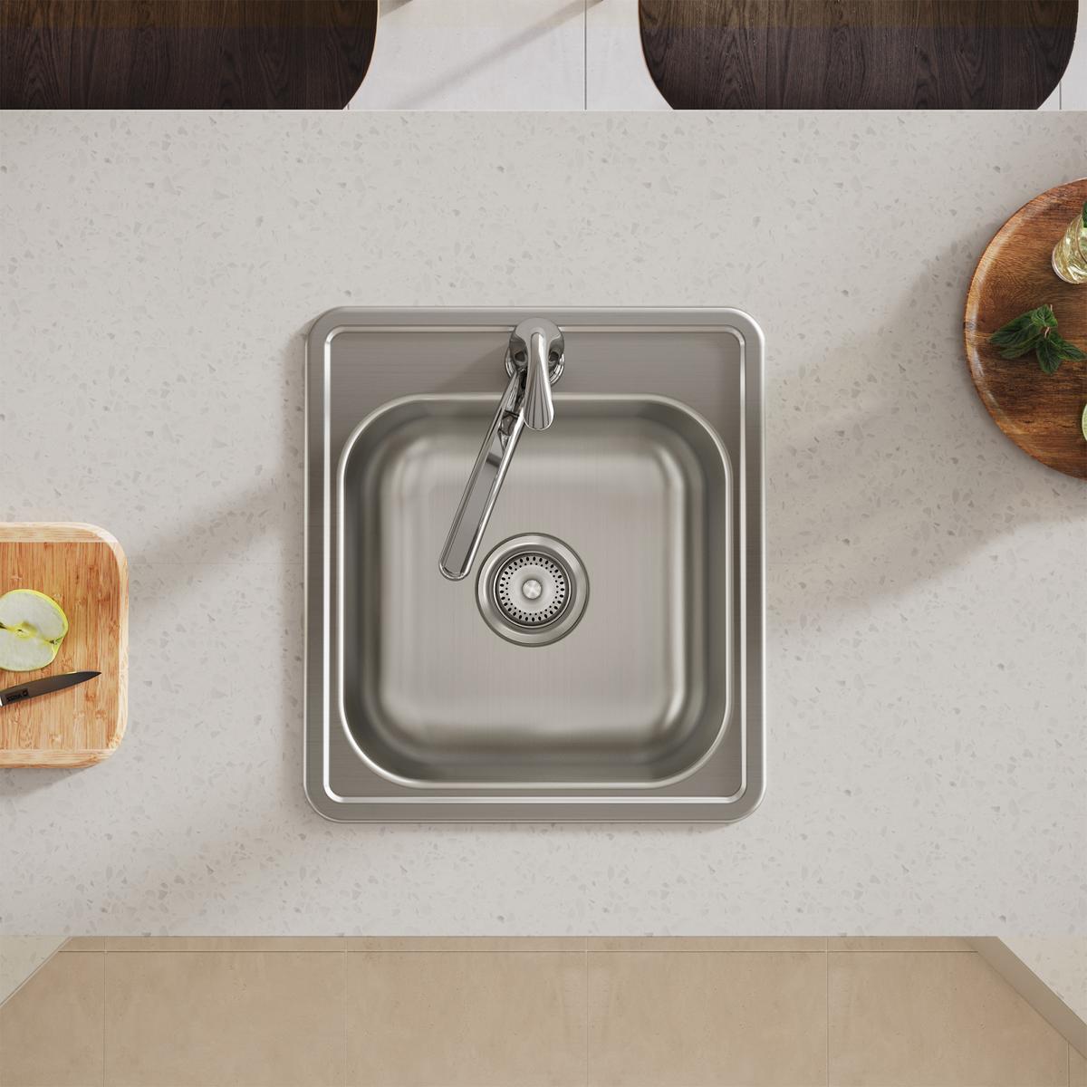Stainless steel drop-in bar sink with single bowl, drain strainer, and faucet installed in quartz countertop.