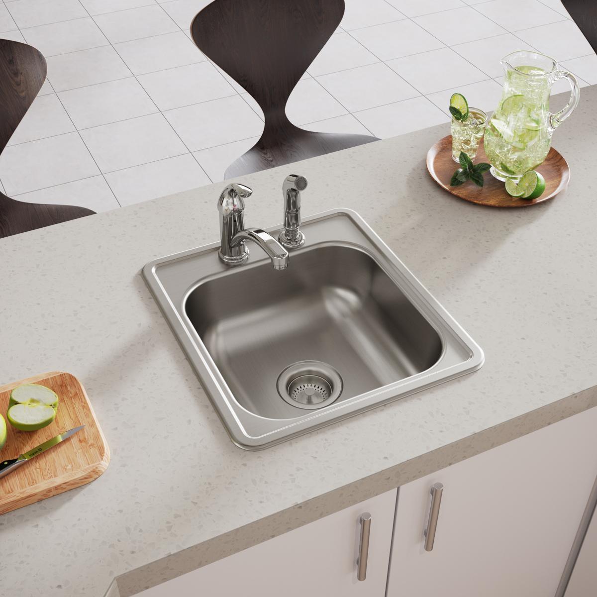 Stainless steel drop-in bar sink with single bowl, two pre-drilled holes, and integrated drain strainer installed in countert
