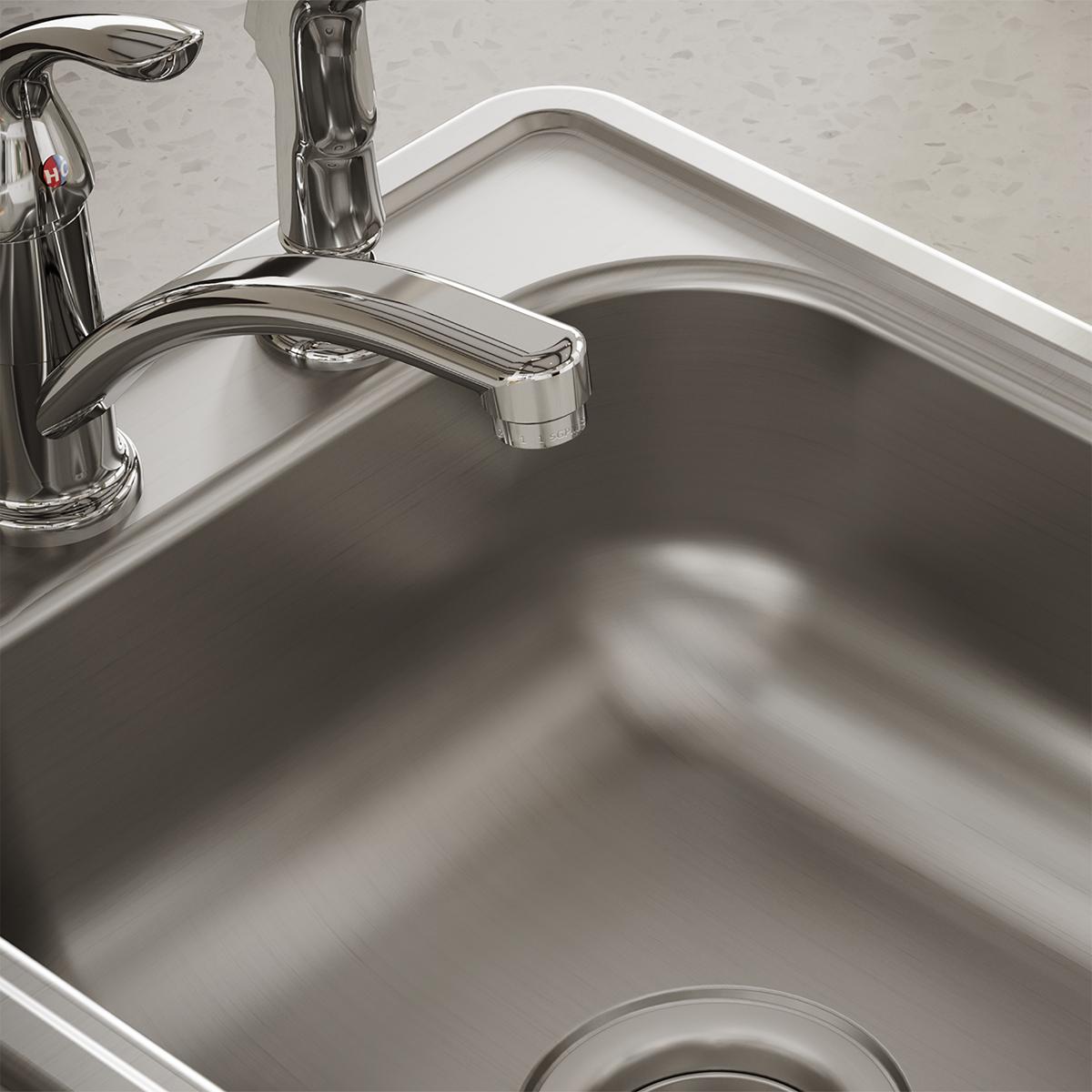 Stainless steel single bowl drop-in bar sink with curved rim and chrome faucet mounted on white countertop.