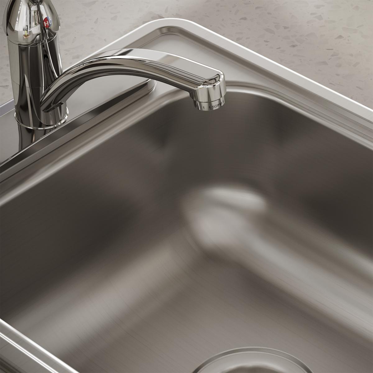 Stainless steel single bowl bar sink with curved rim and chrome faucet mounted on countertop.