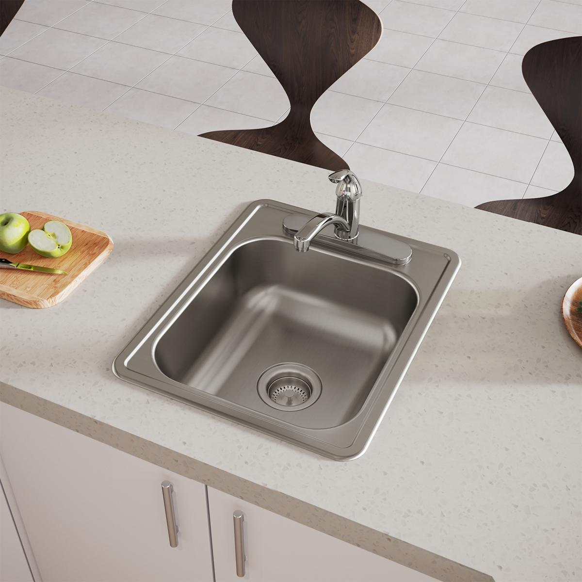 Stainless steel single bowl drop-in sink with faucet mounted in white countertop, featuring strainer and three-hole configura