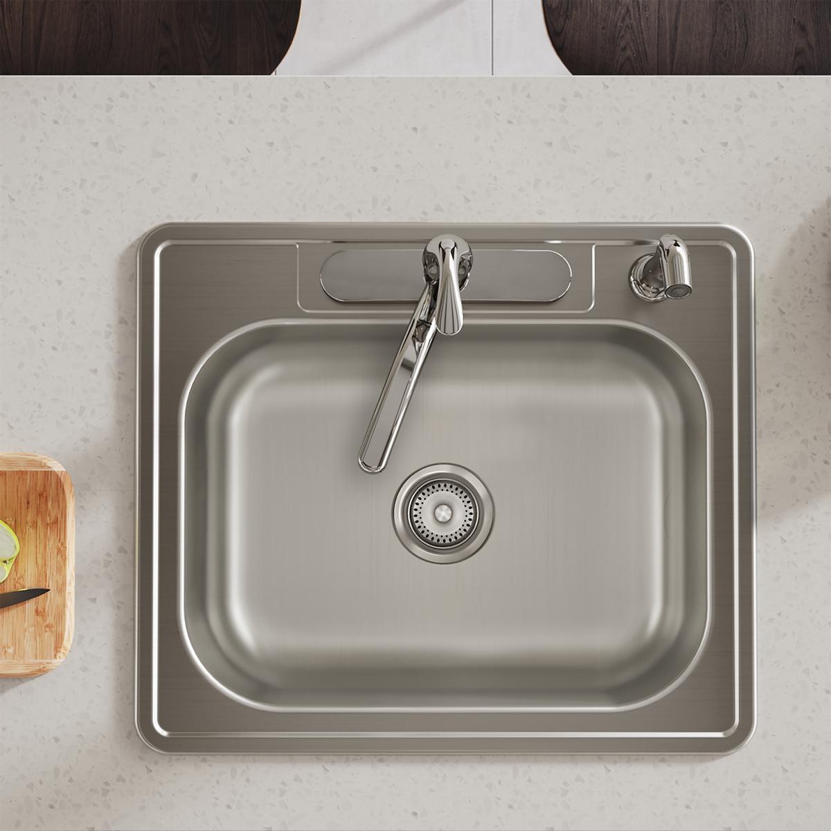 Stainless steel drop-in sink with single bowl, faucet, and drain strainer viewed from above on countertop.