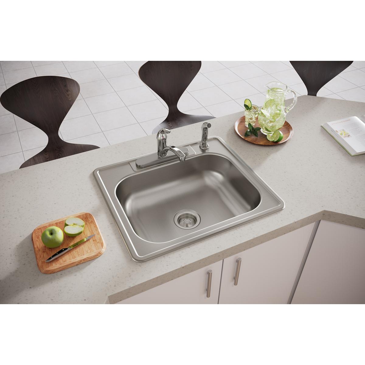 Stainless steel drop-in kitchen sink with single bowl and four holes, installed in countertop with faucet.