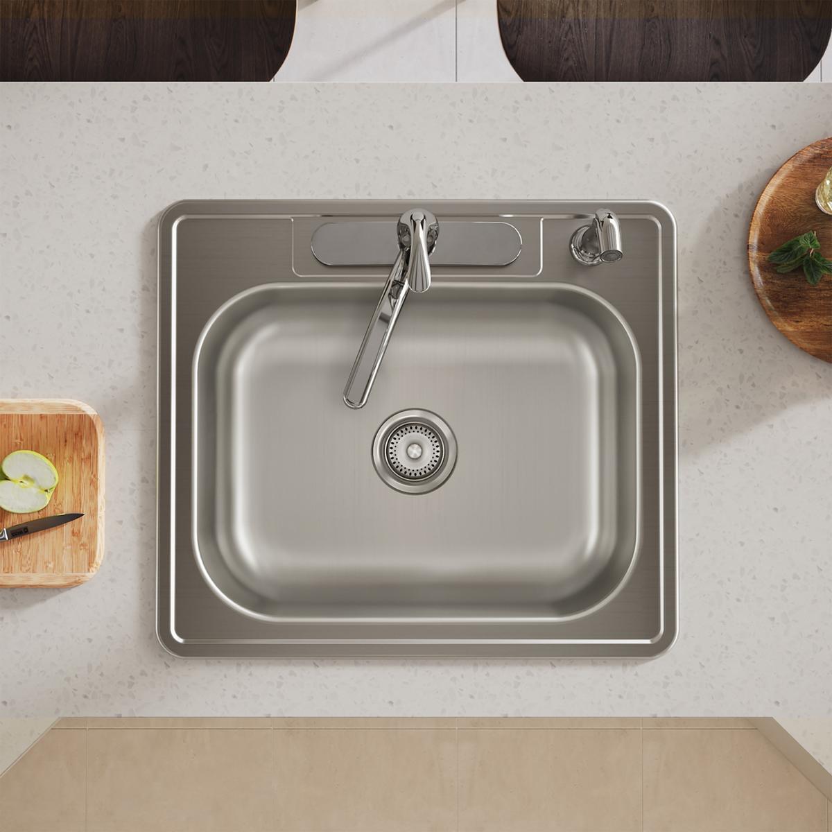 Stainless steel drop-in sink with single bowl, drain strainer, and faucet holes in countertop viewed from above.