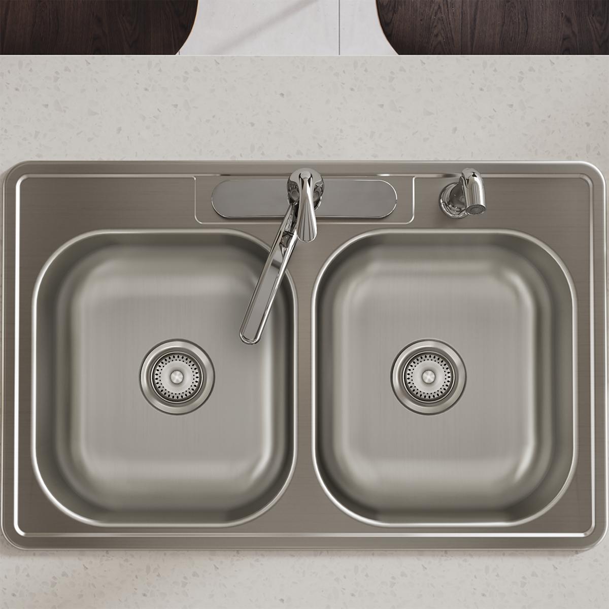 Stainless steel double bowl drop-in sink with two equal basins, drain strainers, and four faucet holes mounted in countertop.