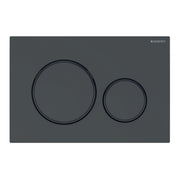 Matte black rectangular actuator plate with two circular flush buttons, larger on left and smaller on right.
