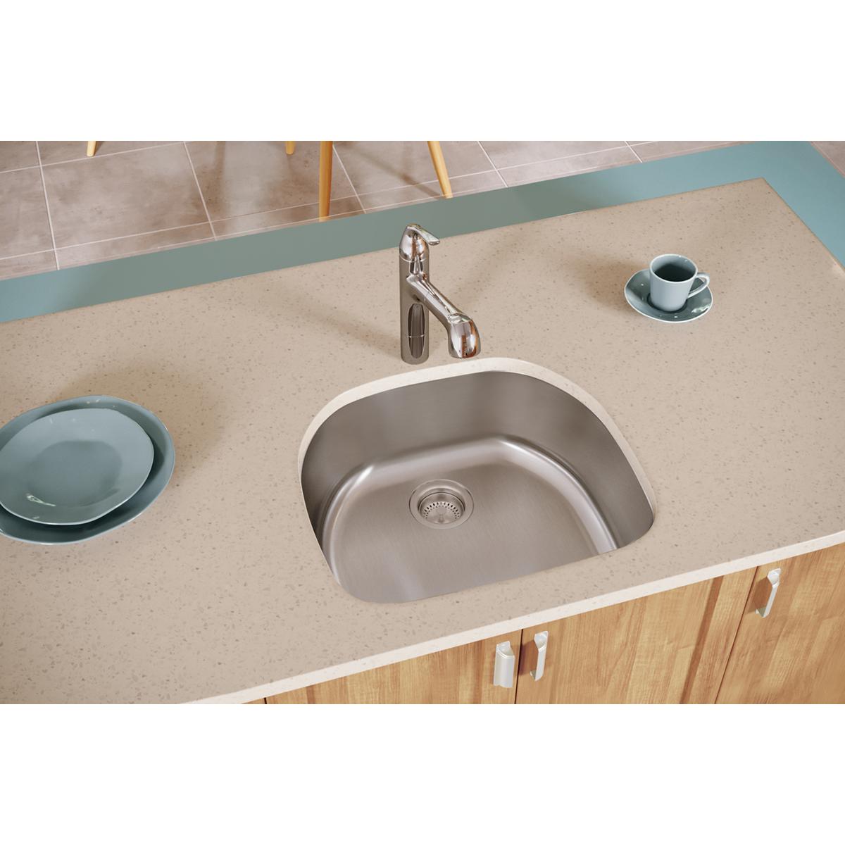 Stainless steel single bowl undermount sink installed in beige countertop with chrome faucet.