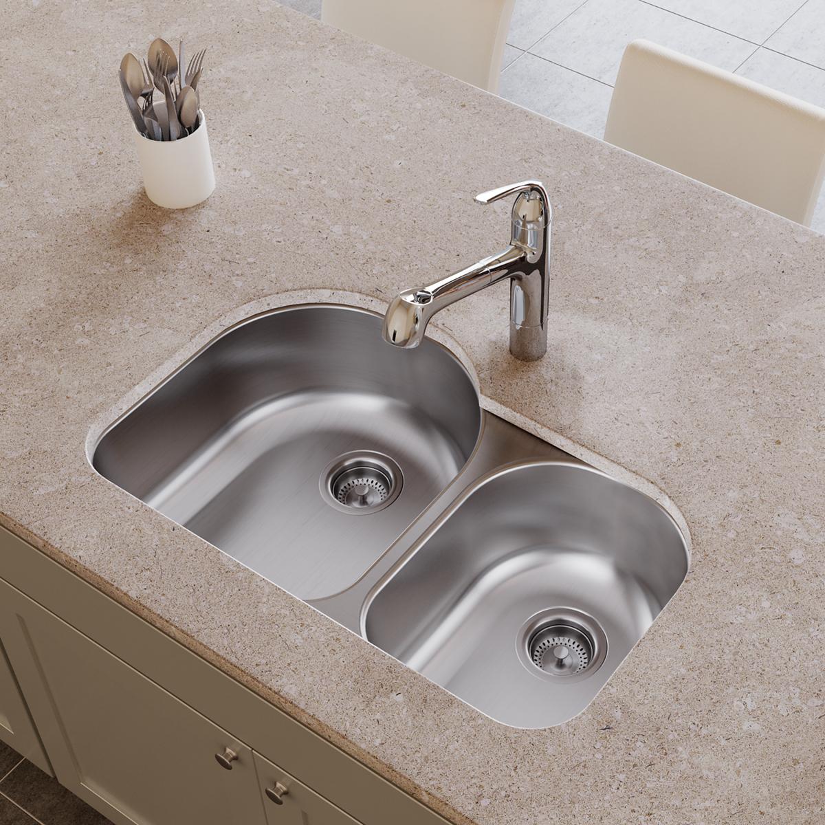 Stainless steel double bowl undermount sink with offset 60/40 configuration and chrome faucet installed in countertop.