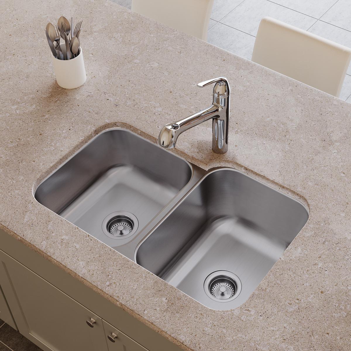 Stainless steel double bowl undermount sink with two compartments and drain strainers installed in countertop.