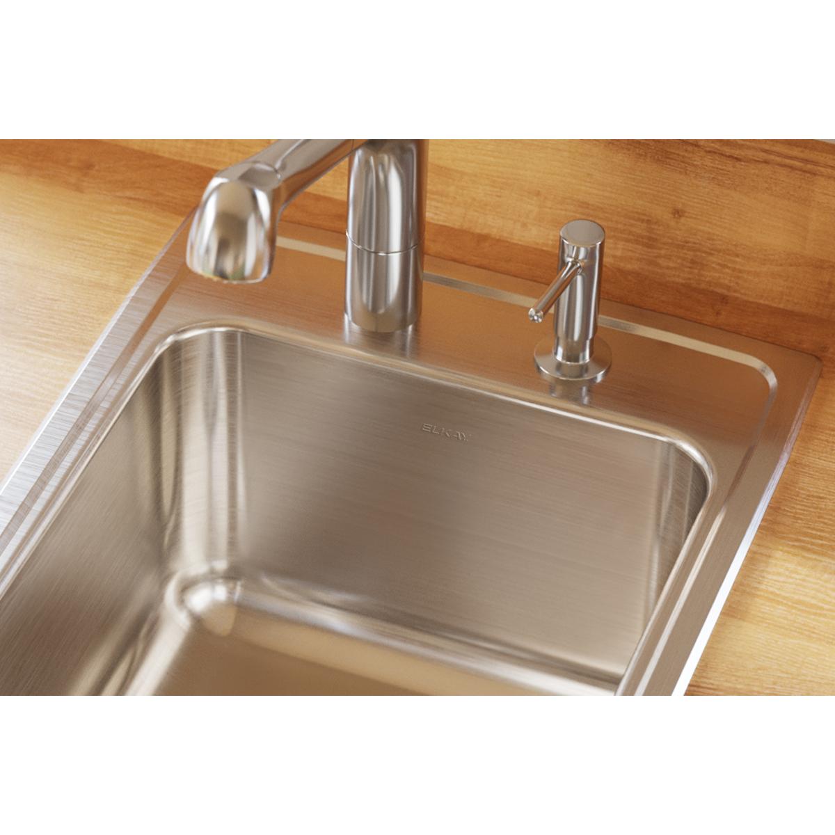 Brushed stainless steel single bowl drop-in sink installed in wood countertop with chrome faucet and sprayer.