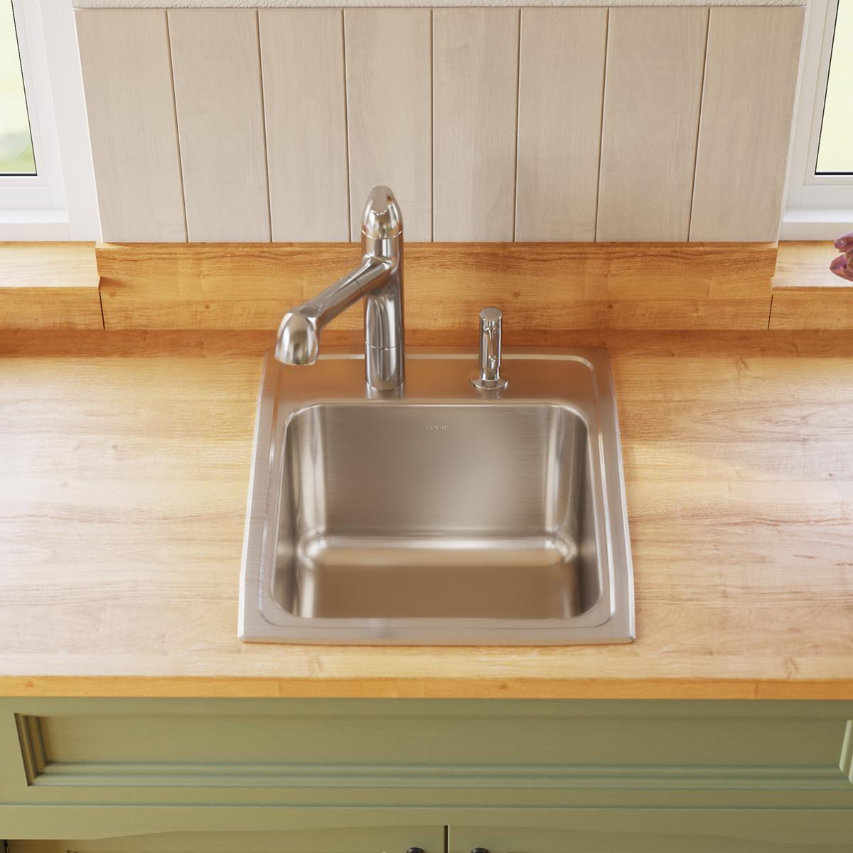 Stainless steel drop-in sink with single bowl and one faucet hole, mounted in wooden countertop with chrome faucet and spray 