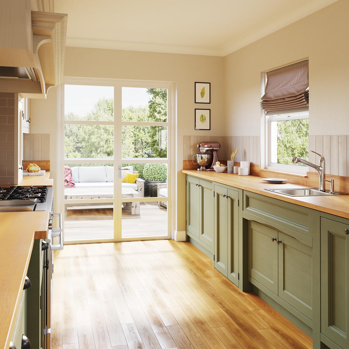 Stainless steel single bowl drop-in sink with brushed finish installed in green cabinetry beneath kitchen window.