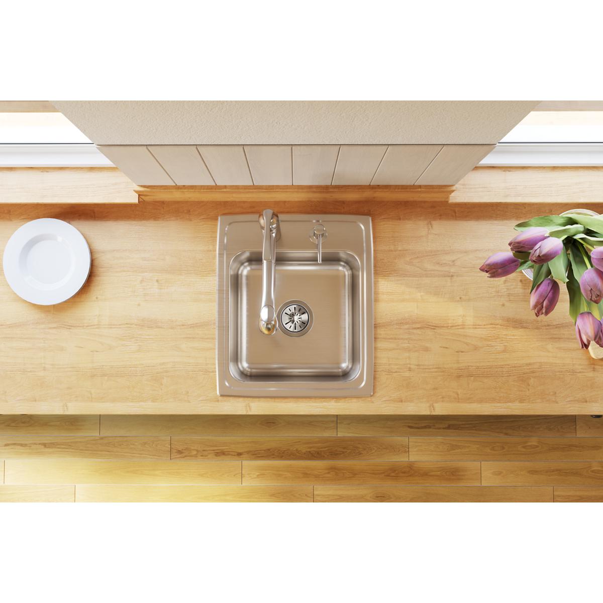 Stainless steel single bowl drop-in sink with faucet installed in wooden countertop, viewed from above.
