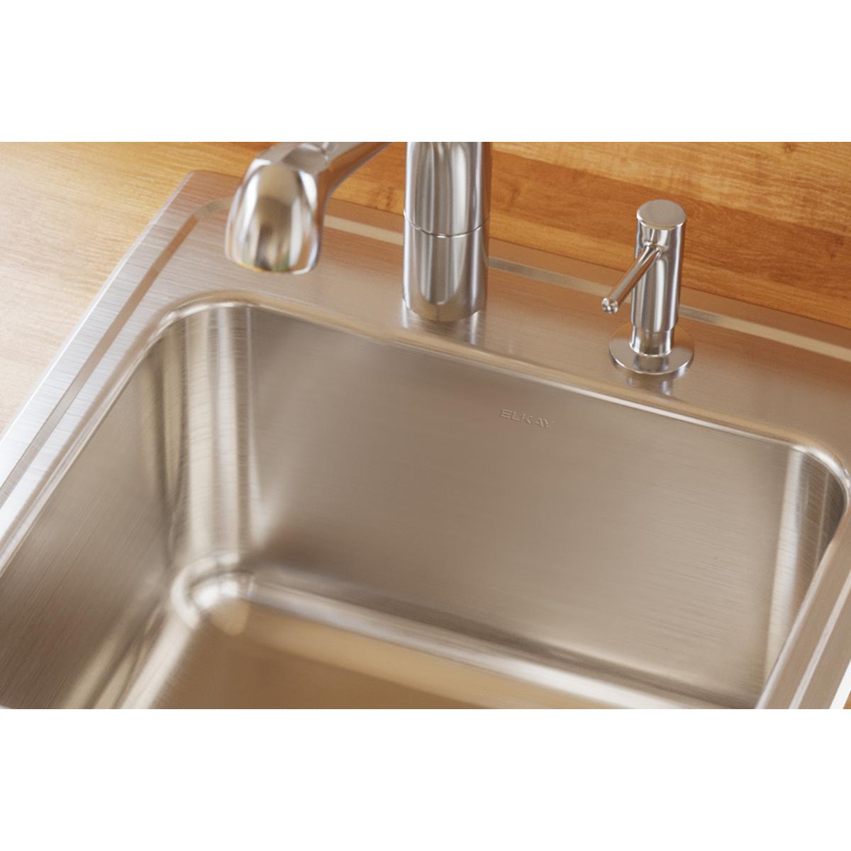 Stainless steel drop-in laundry sink with single bowl, faucet, and spray head installed in wood countertop.