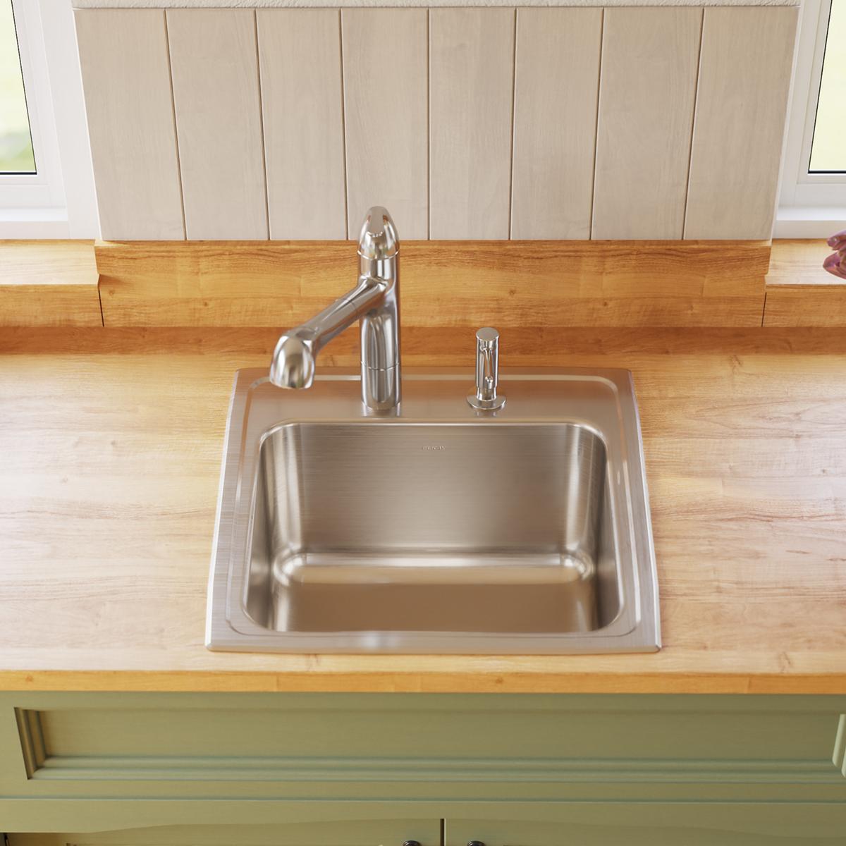 Stainless steel drop-in laundry sink with single bowl, chrome faucet, and soap dispenser mounted on wood countertop.