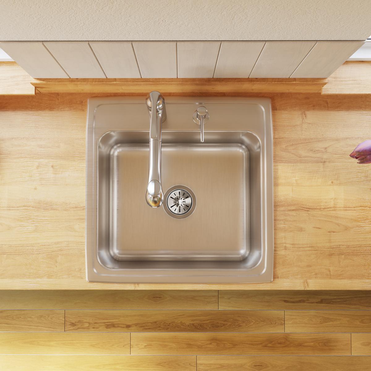 Stainless steel single bowl drop-in sink with brushed finish, three faucet holes, and drain strainer visible from above in wo