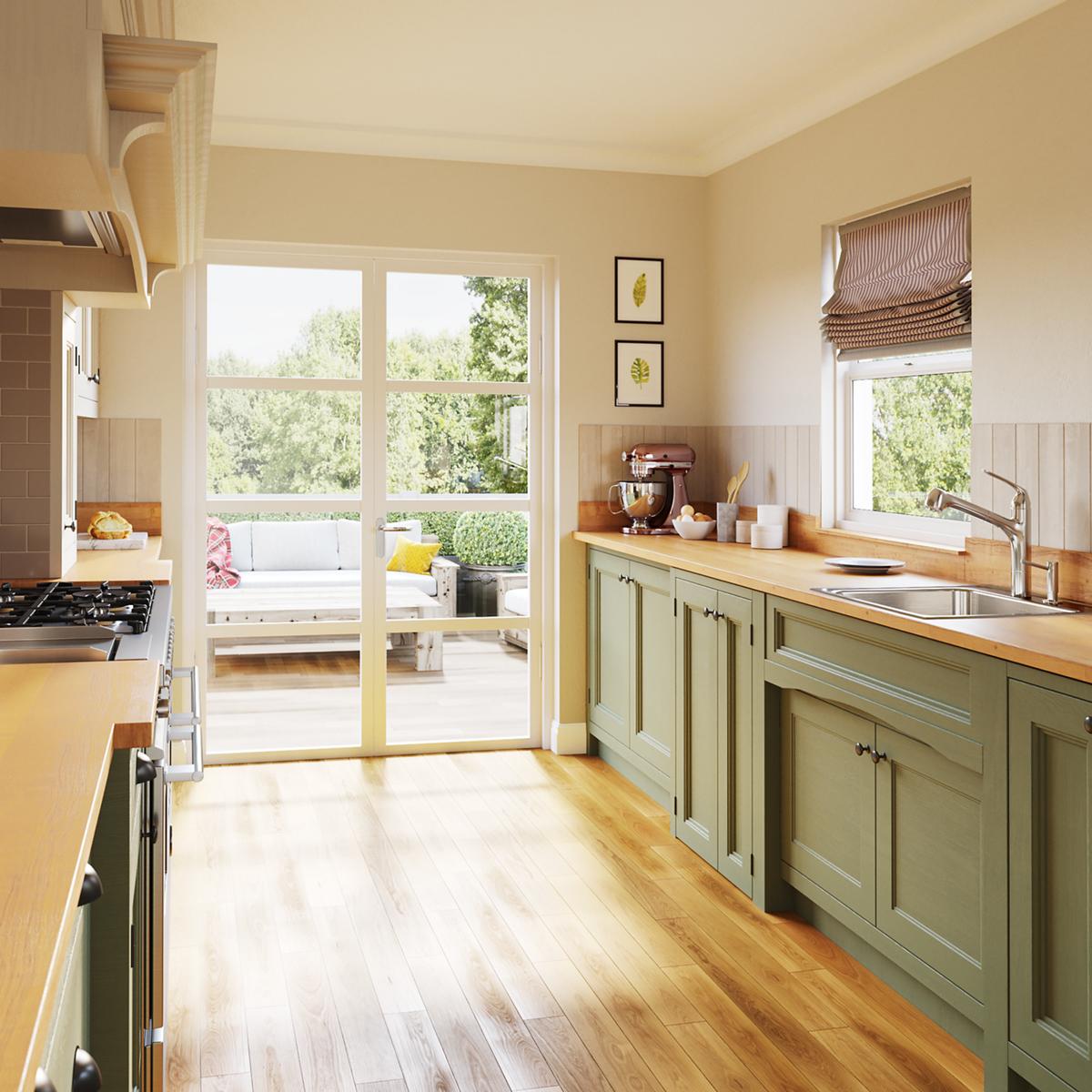 Stainless steel drop-in sink with single bowl and three pre-drilled holes mounted in green cabinetry with wooden countertop.