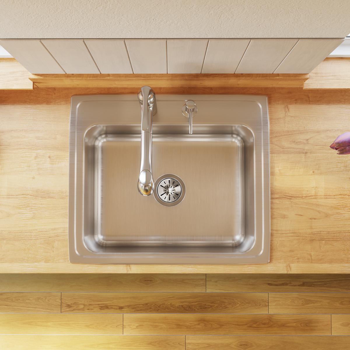 Stainless steel single bowl drop-in sink with faucet and strainer installed in wood countertop, viewed from above.
