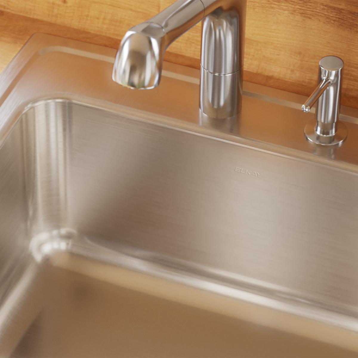 Stainless steel single bowl drop-in sink with one faucet hole, installed in wood countertop with pulldown faucet and soap dis