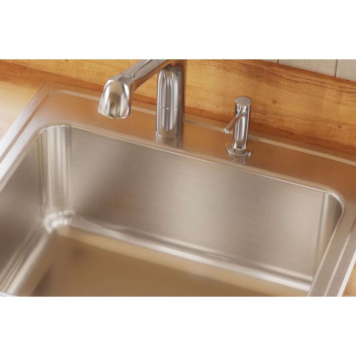 Stainless steel drop-in sink with single bowl and three faucet holes installed in wood countertop with chrome faucet.