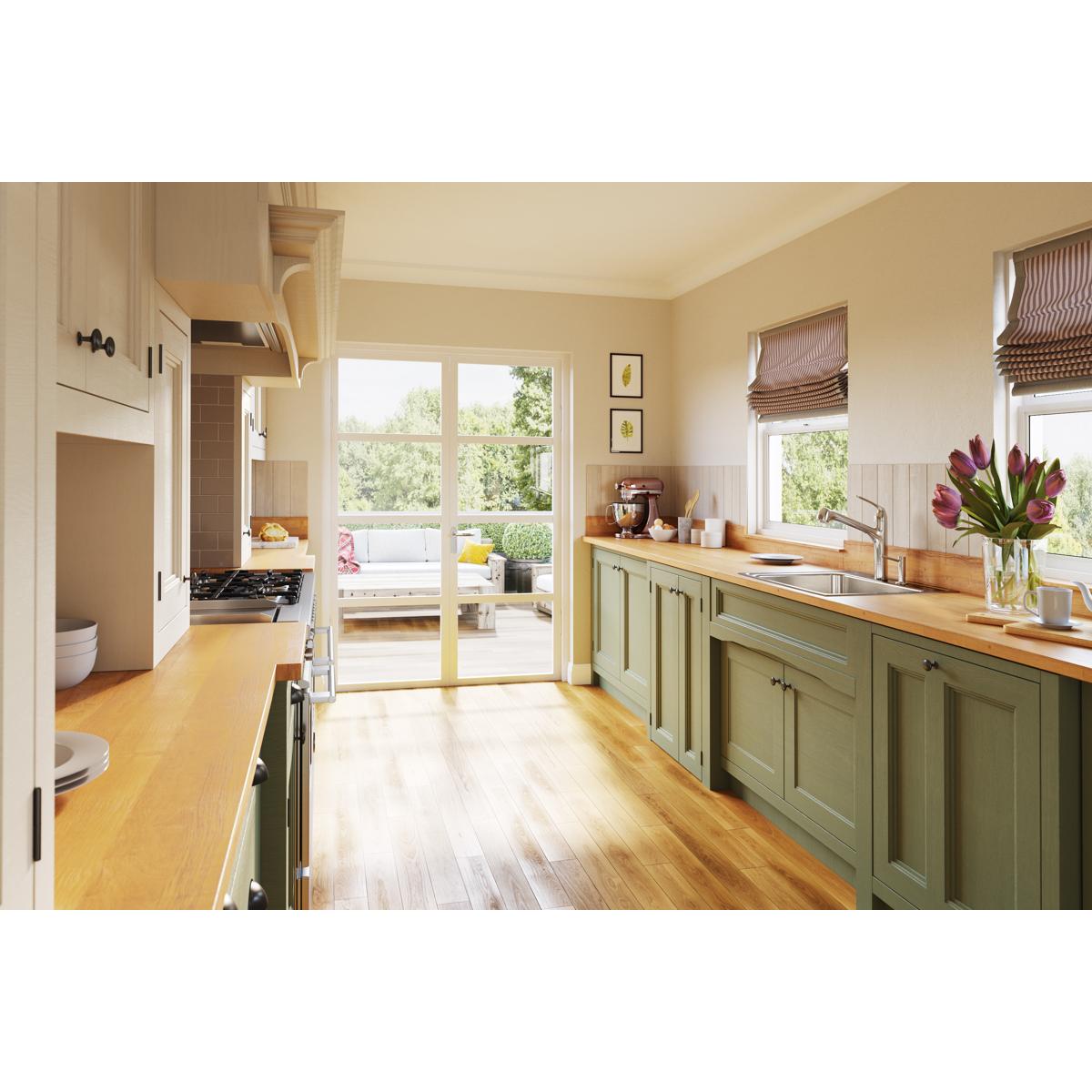 Stainless steel drop-in sink with single bowl and four faucet holes installed in green kitchen cabinetry with wooden countert