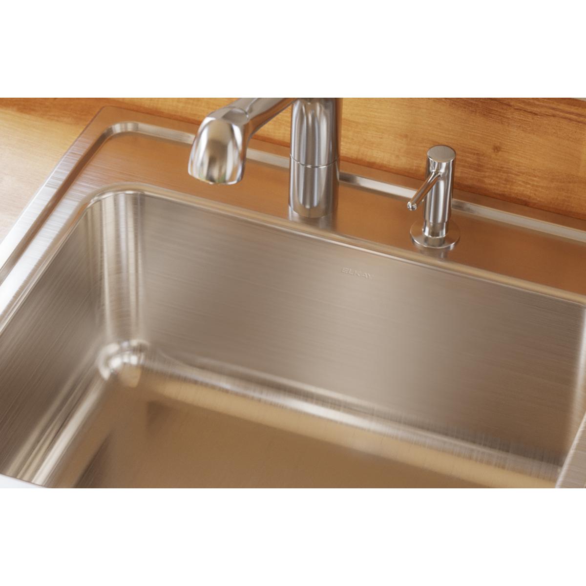 Stainless steel drop-in sink with single bowl installed in wood countertop with faucet and spray attachment.