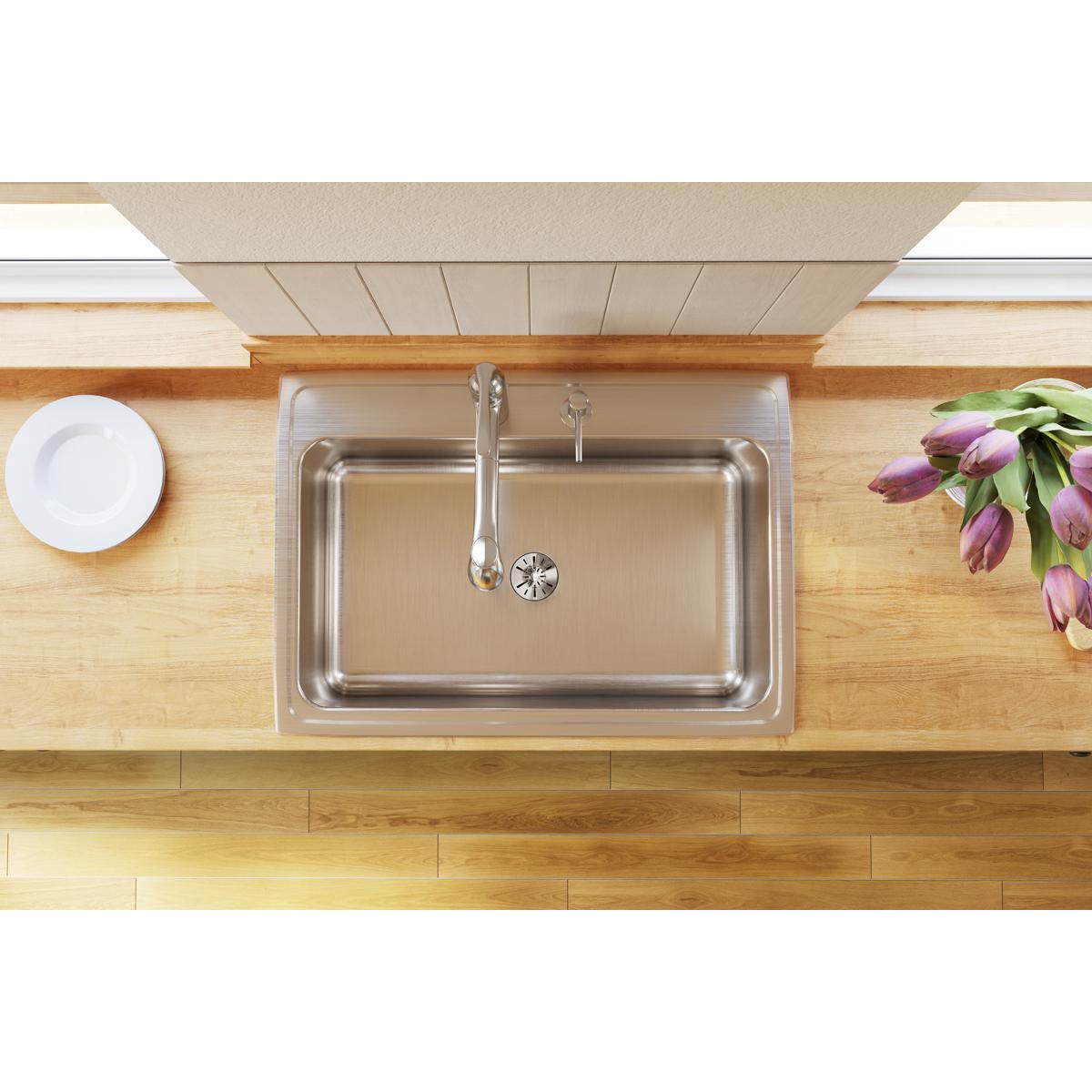 Stainless steel drop-in sink with single rectangular bowl and chrome faucet installed in wood countertop.