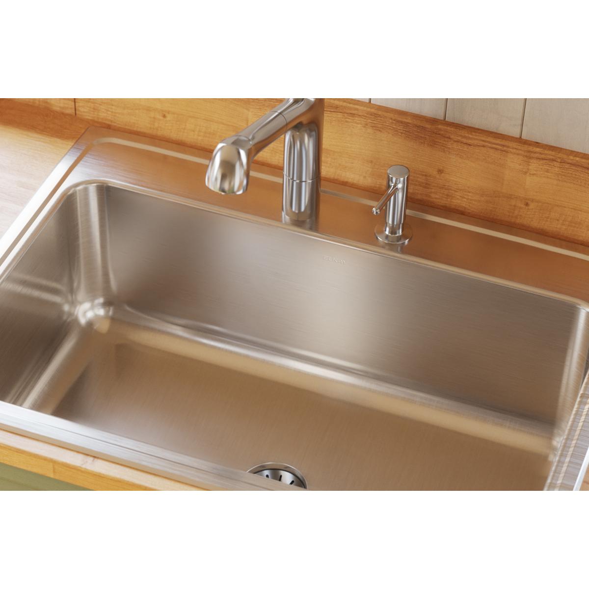 Stainless steel drop-in sink with single bowl installed in wooden countertop, drain visible at bottom.
