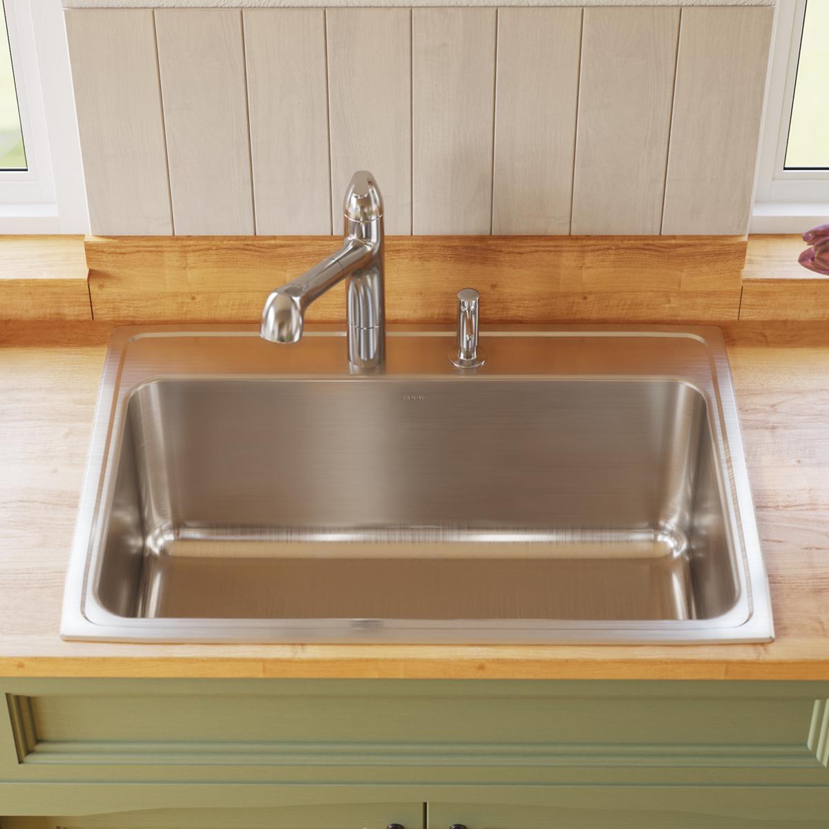 Stainless steel rectangular drop-in sink with single bowl, one faucet hole, and chrome faucet installed on wooden countertop.