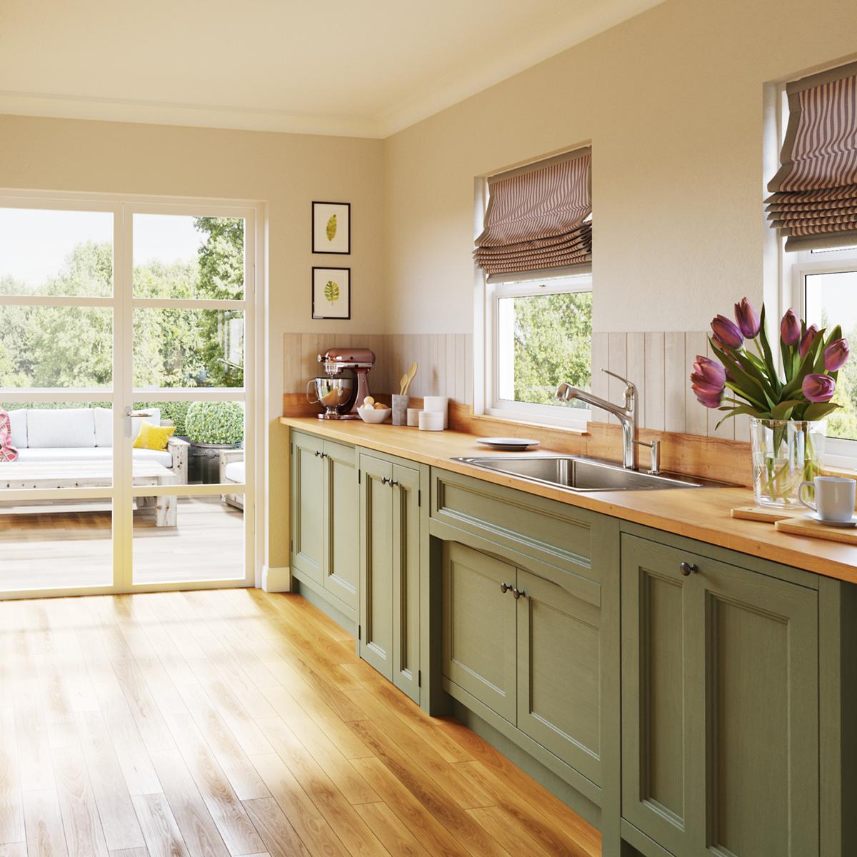 Stainless steel single bowl drop-in sink with brushed finish installed in green kitchen cabinet with wood countertop.